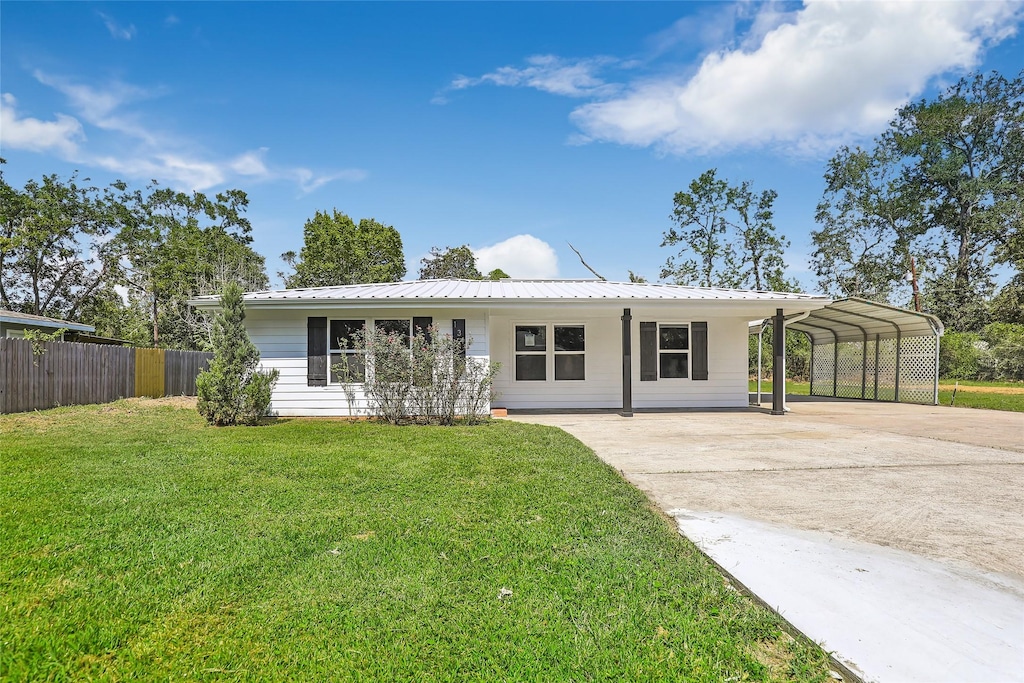 131 County Road 2364, Hardin, TX 77575 - ranch-style home featuring a carport, concrete driveway, and metal roof