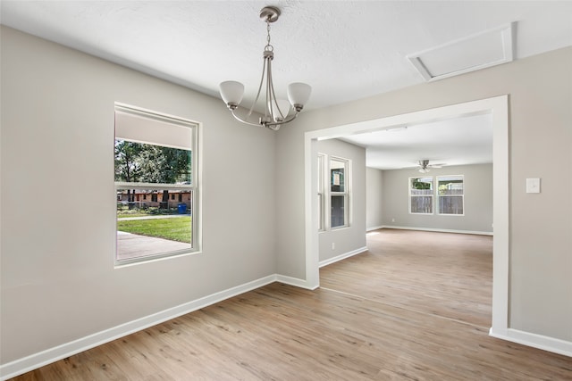 unfurnished dining area with ceiling fan, a textured ceiling, and hardwood / wood-style floors