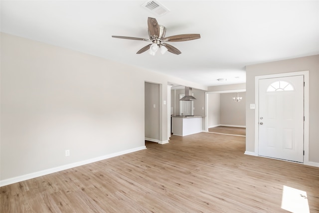 unfurnished living room with light hardwood / wood-style floors and ceiling fan with notable chandelier