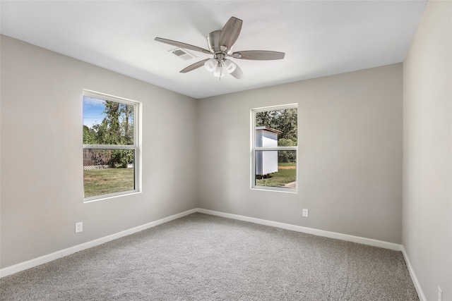 carpeted spare room featuring ceiling fan