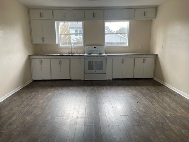 kitchen with dark hardwood / wood-style floors, white range with electric cooktop, sink, and plenty of natural light