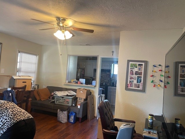 interior space featuring ceiling fan, dark wood-type flooring, and a textured ceiling