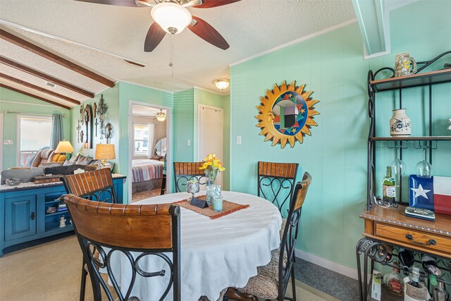 dining space with ceiling fan, a healthy amount of sunlight, light colored carpet, and vaulted ceiling with beams