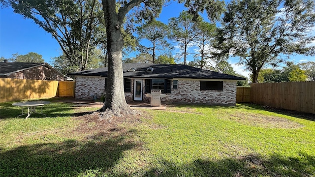 back of property with a lawn and a patio