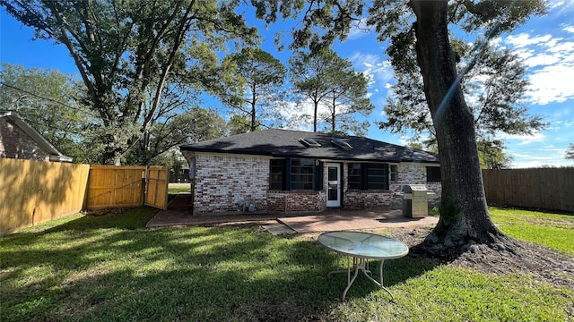 back of property featuring a lawn and a patio area