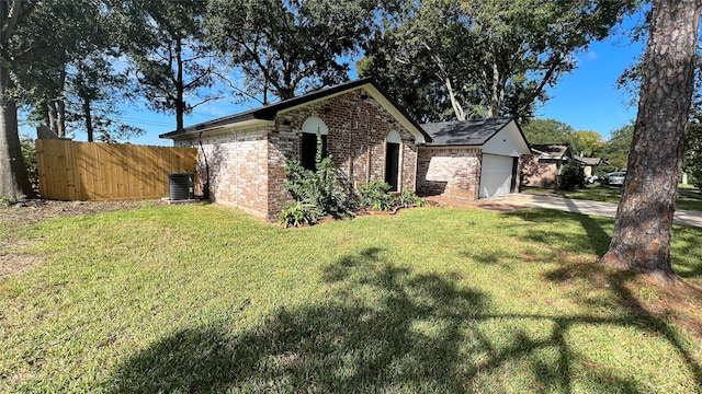 view of home's exterior with central AC unit, a garage, and a yard