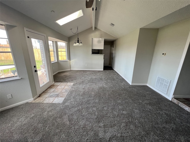 unfurnished living room featuring carpet and vaulted ceiling with skylight