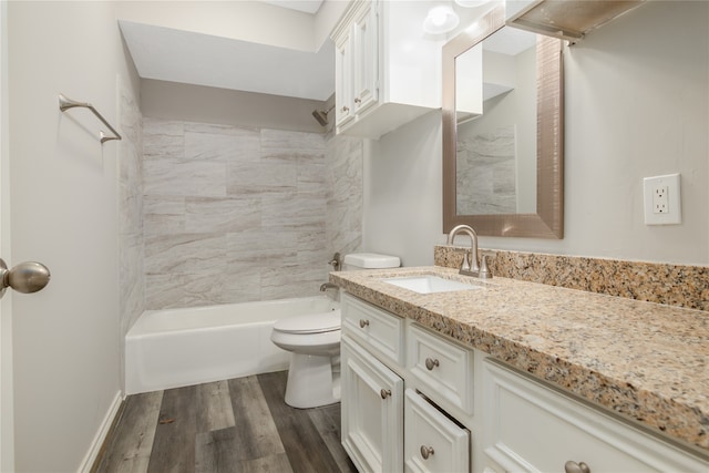 full bathroom featuring hardwood / wood-style flooring, tiled shower / bath combo, toilet, and vanity