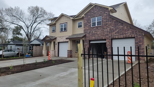 view of front of property featuring brick siding, driveway, a garage, and fence