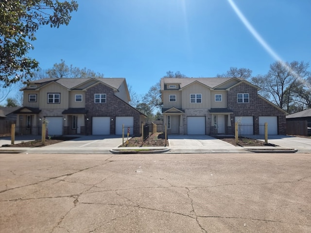 view of front of house featuring a garage, concrete driveway, and fence