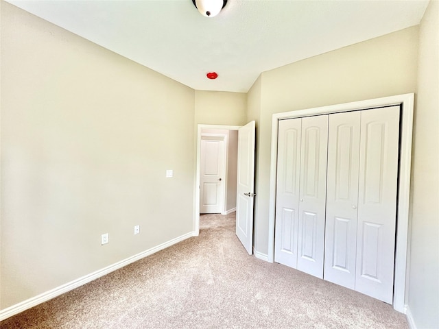 unfurnished bedroom with a closet, baseboards, and carpet flooring