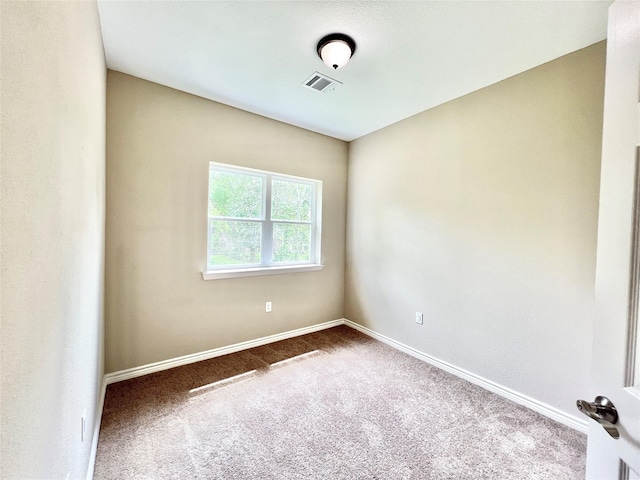 empty room with baseboards, visible vents, and carpet floors