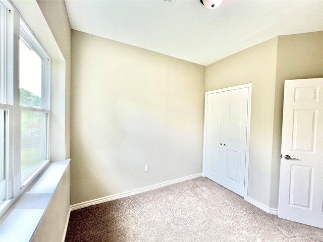 unfurnished bedroom with baseboards, carpet floors, and a closet