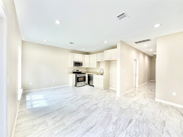 kitchen featuring stainless steel appliances, visible vents, open floor plan, and light countertops