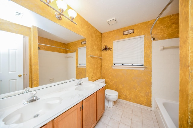 full bathroom featuring vanity, tiled shower / bath, tile patterned floors, and toilet