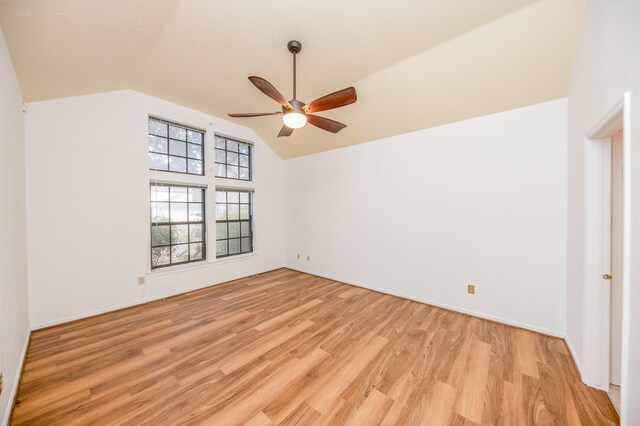 spare room with vaulted ceiling, ceiling fan, and light wood-type flooring