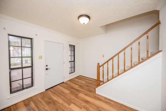 foyer with ornamental molding and light wood-type flooring