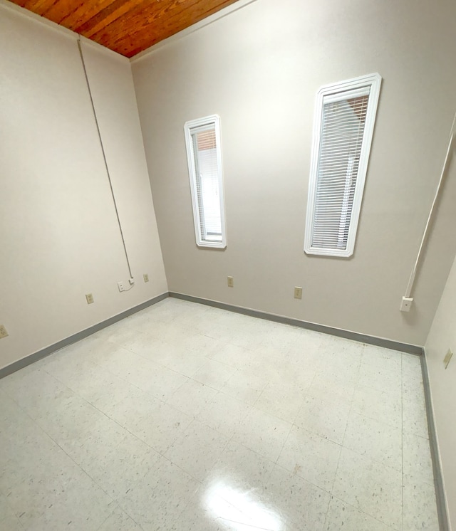 tiled spare room with wooden ceiling