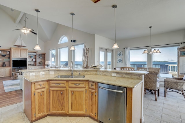 kitchen with a healthy amount of sunlight, a kitchen island with sink, sink, and stainless steel dishwasher