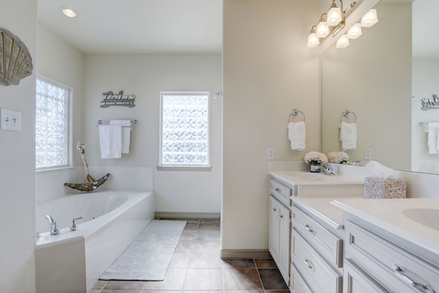 bathroom featuring tile patterned floors, a tub, vanity, and a healthy amount of sunlight