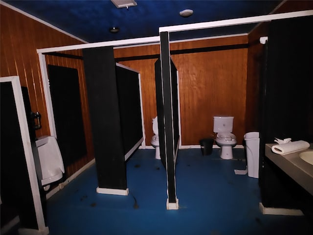 bathroom with wood walls and toilet