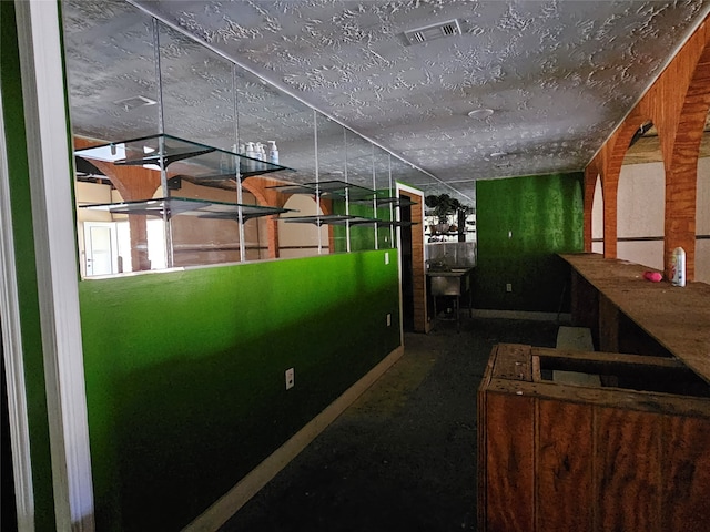 corridor featuring a textured ceiling