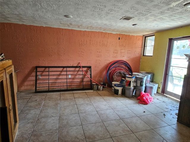 interior space featuring a textured ceiling and tile patterned flooring