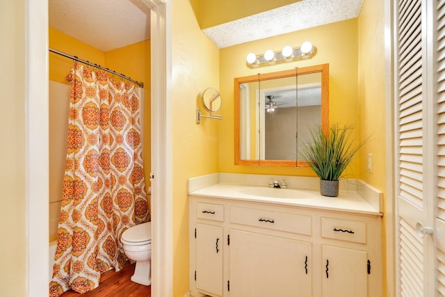 bathroom with hardwood / wood-style floors, vanity, a textured ceiling, and toilet