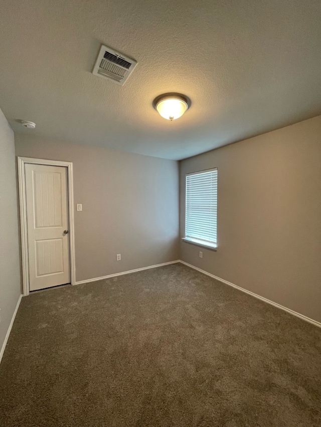 carpeted empty room with a textured ceiling