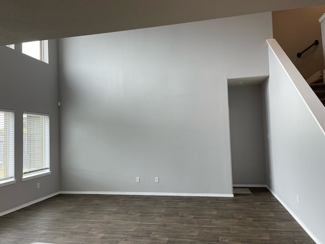 empty room with wood-type flooring and a high ceiling