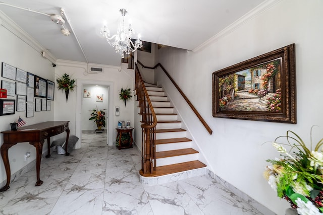 entryway featuring an inviting chandelier and crown molding