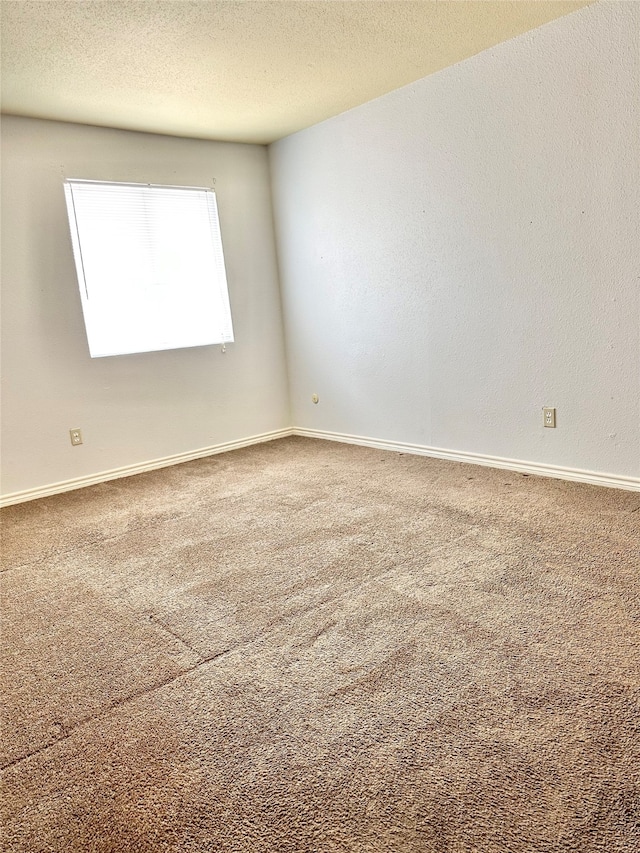 empty room featuring a textured ceiling and carpet flooring