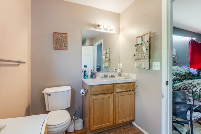 bathroom with vanity, toilet, and hardwood / wood-style floors