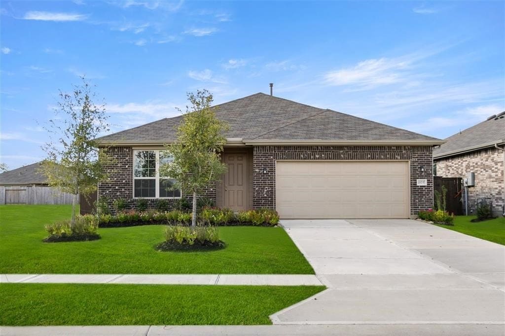 single story home featuring a garage and a front lawn