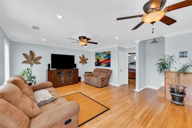 living room with crown molding, ceiling fan, and light hardwood / wood-style flooring