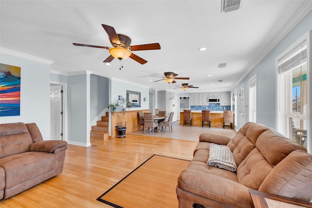 living room with ornamental molding and light hardwood / wood-style floors