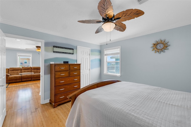 bedroom with ceiling fan, ornamental molding, and light hardwood / wood-style flooring