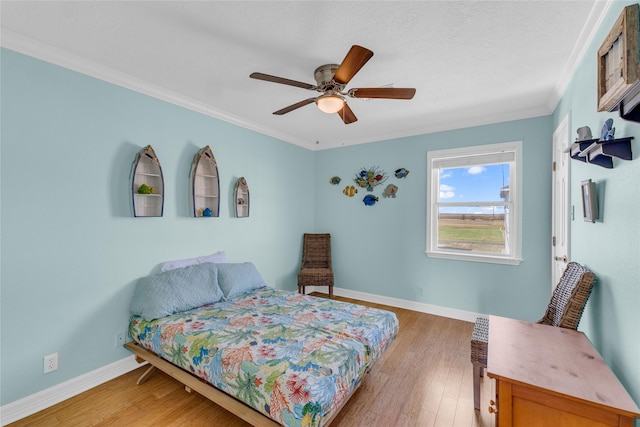 bedroom featuring ornamental molding, ceiling fan, and light hardwood / wood-style floors