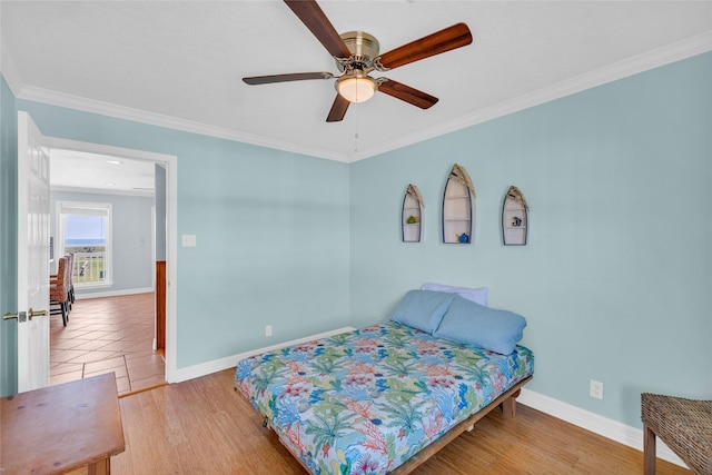 bedroom featuring ceiling fan, ornamental molding, and wood-type flooring