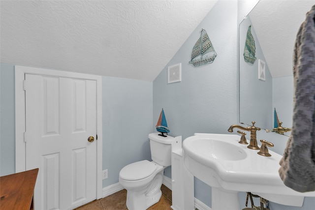 bathroom with sink, vaulted ceiling, tile patterned floors, and toilet