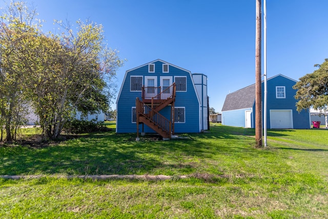 rear view of house with a deck, a garage, and a lawn