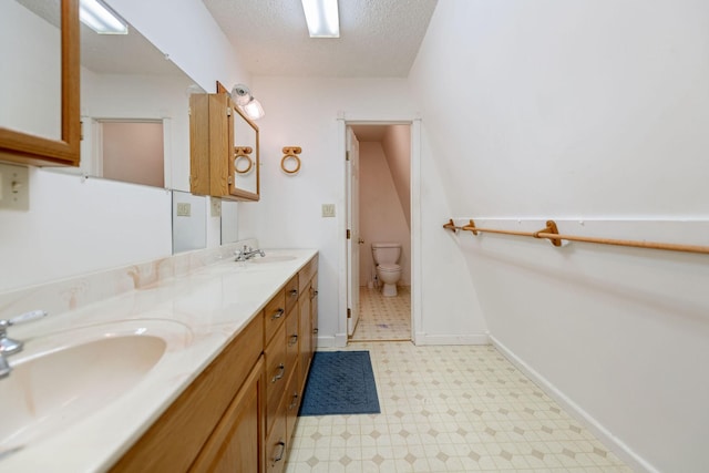 bathroom featuring toilet, vanity, and a textured ceiling