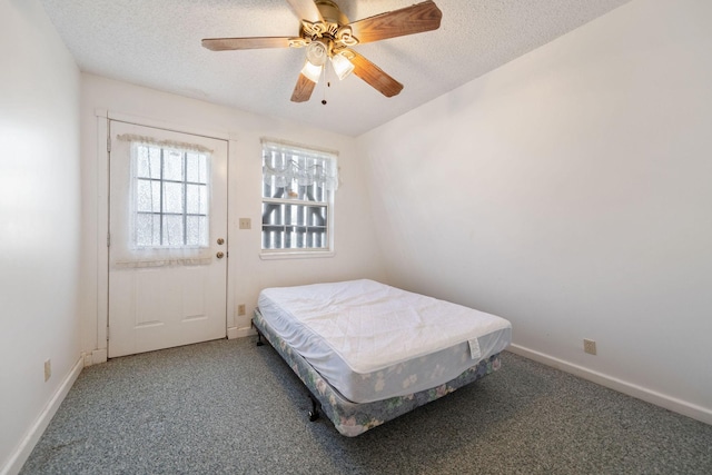 bedroom with ceiling fan, carpet, and a textured ceiling