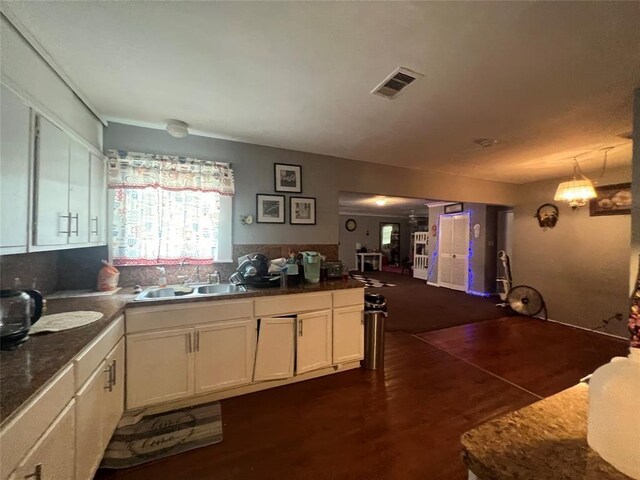 kitchen with sink, white cabinets, and backsplash