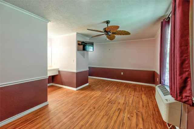 spare room featuring a textured ceiling, ceiling fan, crown molding, and wood-type flooring