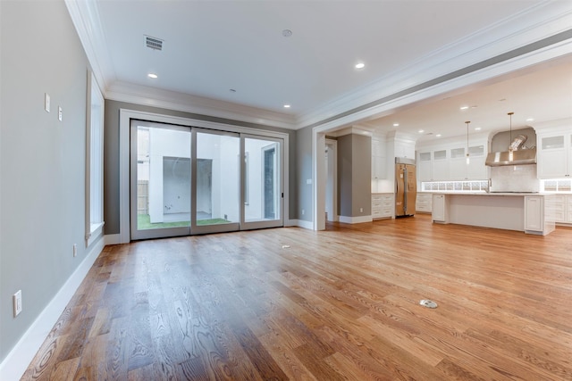 unfurnished living room with ornamental molding and light hardwood / wood-style flooring