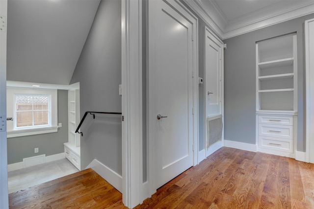 interior space featuring hardwood / wood-style floors, built in shelves, and ornamental molding