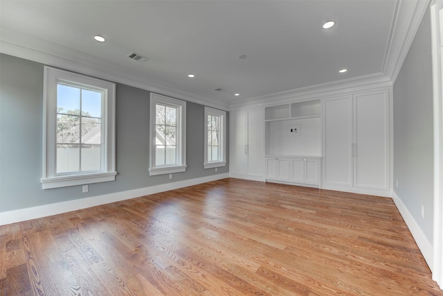 spare room with ornamental molding and light hardwood / wood-style floors