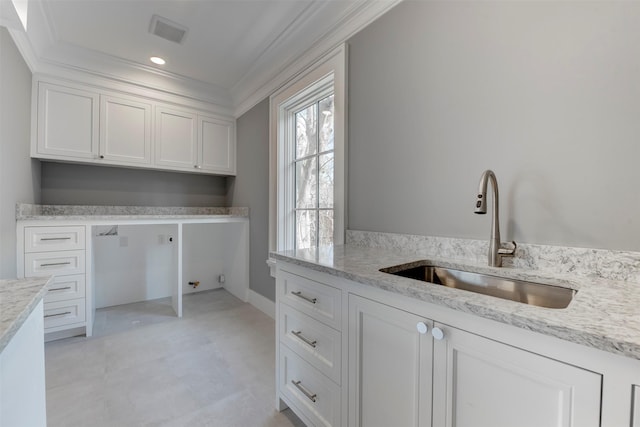 washroom featuring sink, ornamental molding, and cabinets