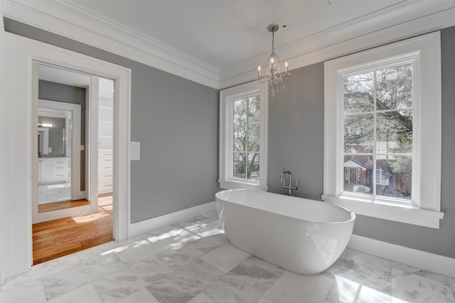 bathroom featuring crown molding, a tub, and a chandelier